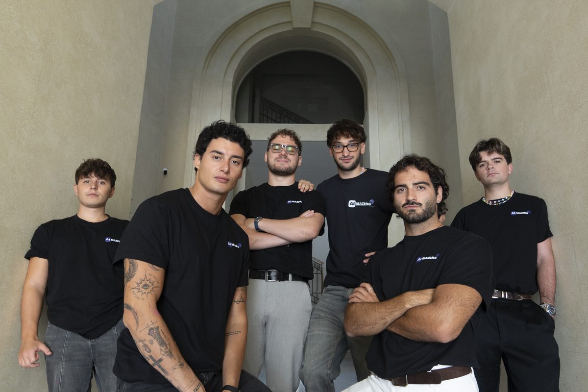Il team Aimazing a Terni: sei persone con la maglia Aimazing davanti a un portone ad arco